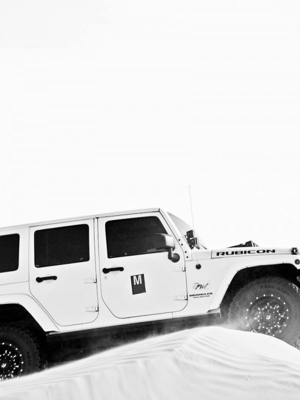 Grayscale Photo of White Jeep on Sand Dune